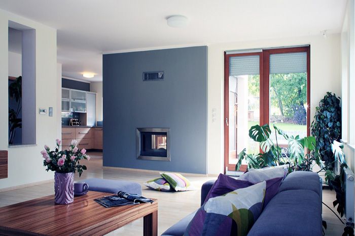 Obývacia izba je od jedálne oddelená stenou s priehľadnou kozubovou vložkou. V interiéri dominuje dyha zebrano, ktorú dopĺňajú neutrálne odtiene šedej a svetlo citrónová. 