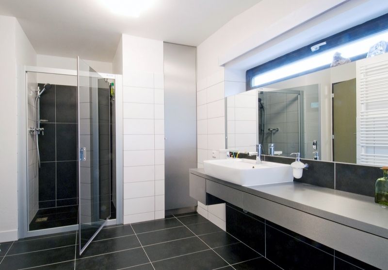 Kúpeľňa na prízemí ctí základnú farebnú škálu čiernej, šedej a bielej.