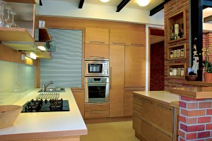 Materiály a farby použité v kuchyni harmonizujú s celkovou farebnou náladou interiéru. Motívy drevených výklenkov nájdeme aj na nezvyčajných miestach, napríklad v kúpeľni.