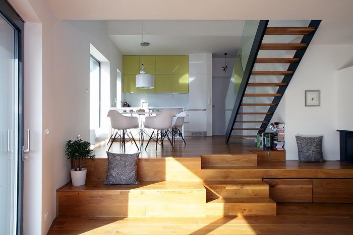 Srdcom domu je rozsiahly otvorený denný priestor s kuchyňou a jedálňou na vstupnej úrovni a s o pár schodov nižšie položenou obývačkou.