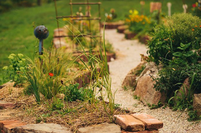 Suchý múrik zo starých škridiel, dreva, kameňa a tehál v nepravidelnom organickom tvare dodal záhrade neuveriteľné čaro.