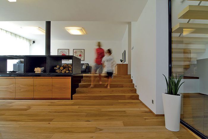 Na vstavaný nábytok a podlahy obytného priestoru sa použilo brestové a dubové drevo. Vďaka štyri milimetre hrubej dyhe pôsobí podlaha ako masív. Čierny kozub, kuchynský nábytok, vonkajšie i vnútorné zasklievanie – všetko sa objednávalo a robilo na mieru podľa architektonického projektu.